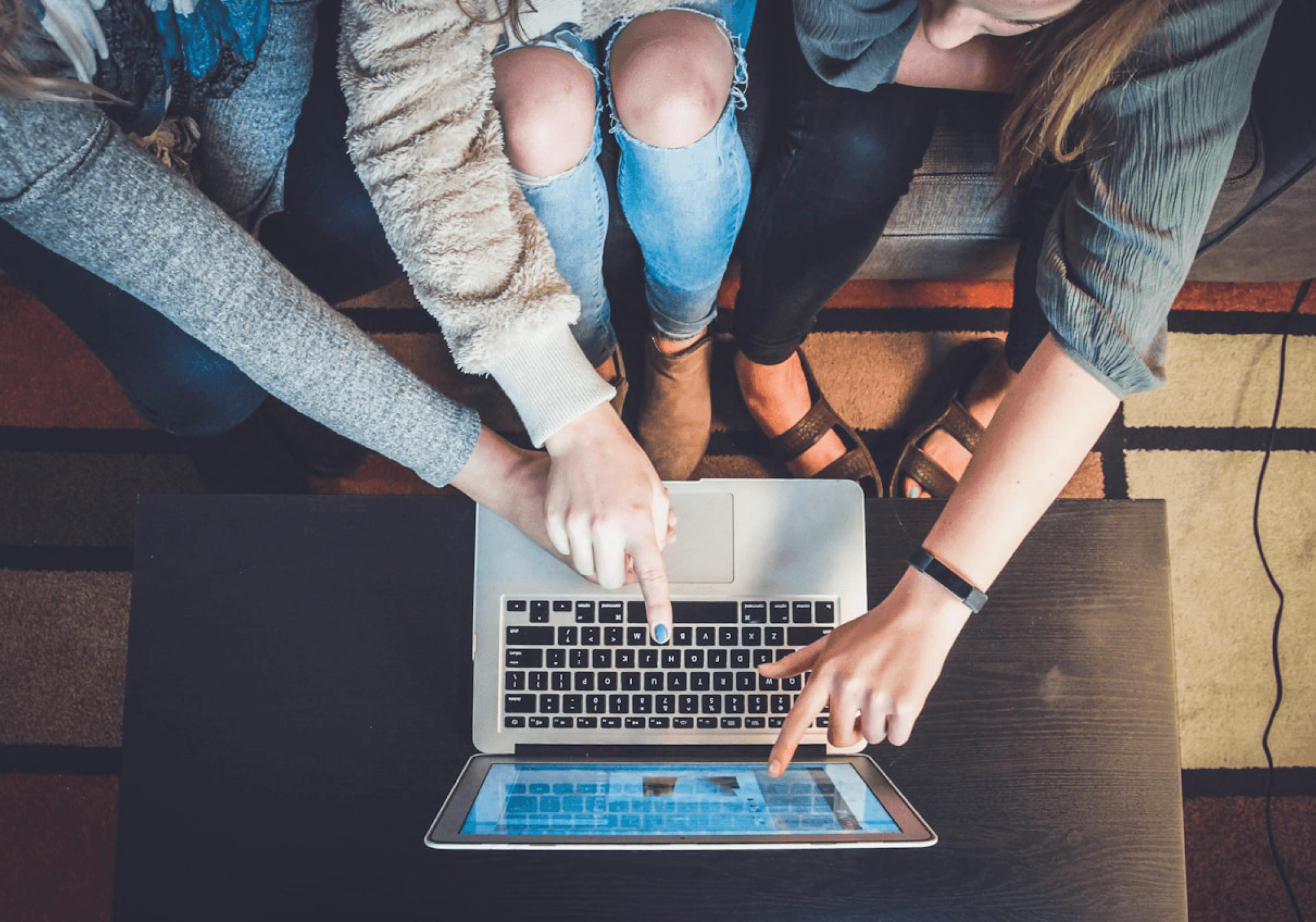 People looking at the code on a laptop, ensuring its security is stable.